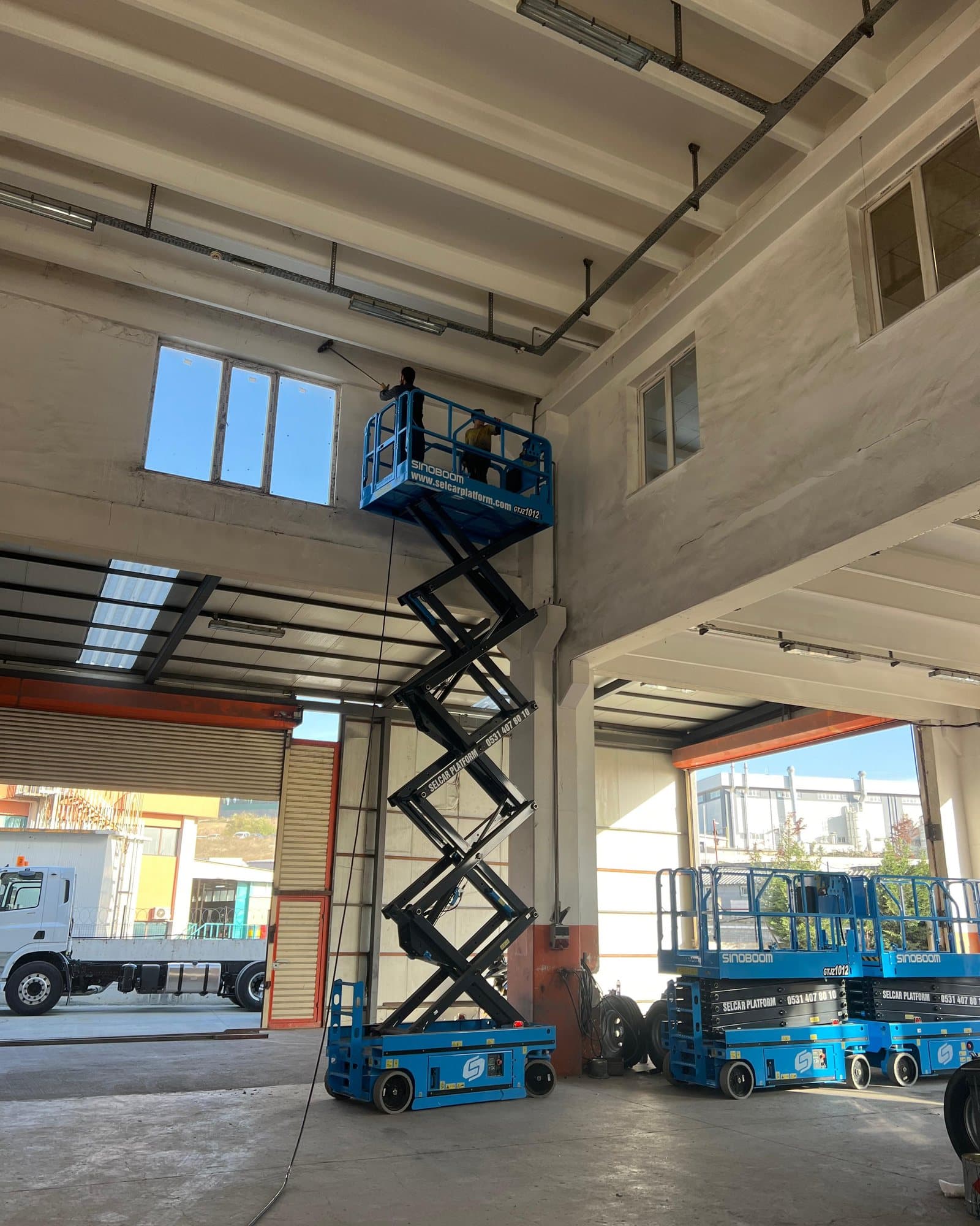 Fabrika içinde makaslı platformla yüksekte çalışan ekip